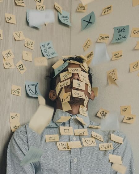 man overwhelmed with sticky notes